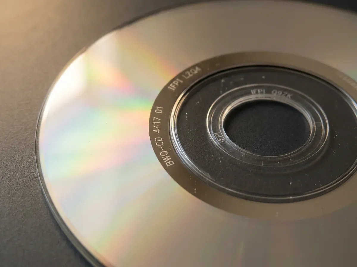 Illustration of the playing side of a fictional CD, Saltmarsh Telegraph: BWQ-CD 4417 01 and IFPI LZQ4 etched in the shiny band around the center hole, and IFPI Q9ZK and part of a second IFPI mark in the clear inner ring